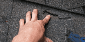 hand pointing to roof damage